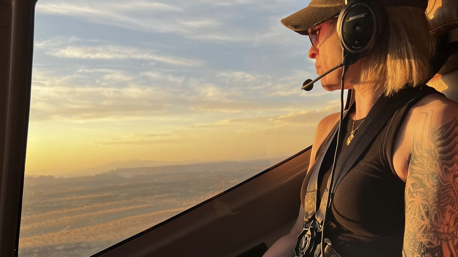 Heather McCuen in a helicopter headset at sunset, overlooking the Las Vegas valley